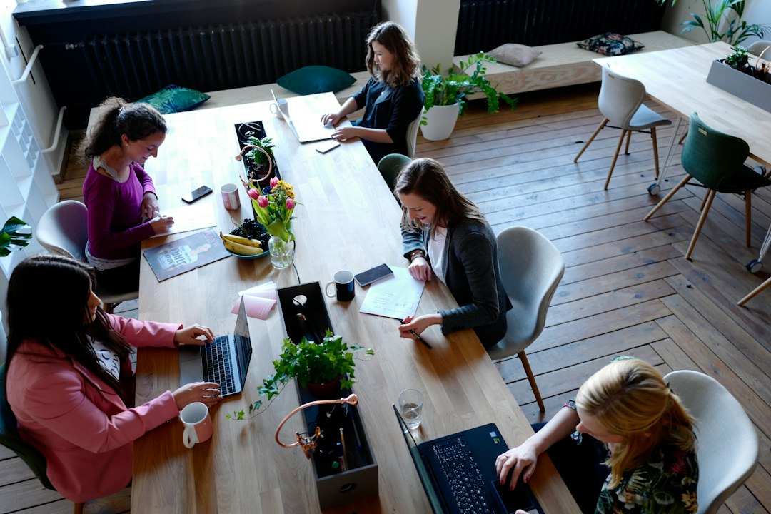 Usagers d’un coworking travaillant en autonomie autour d’une grande table