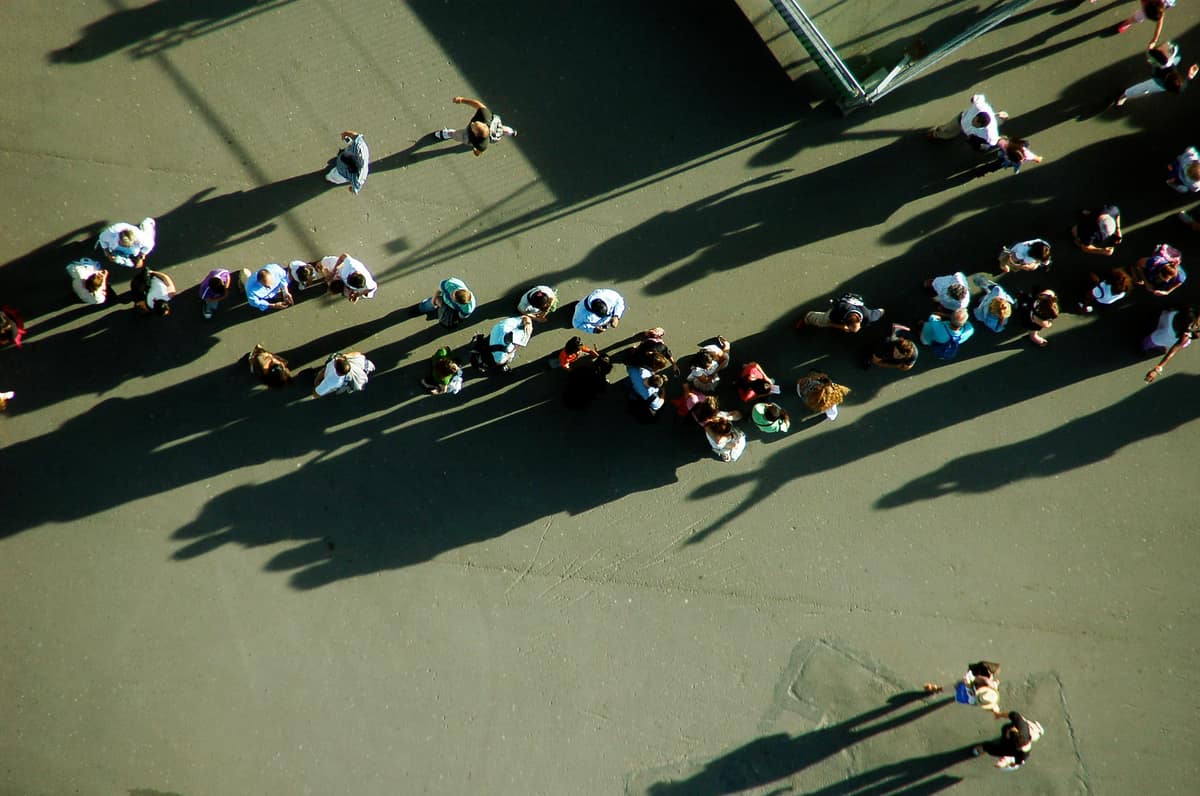 Foule d’usagers vue du ciel se dirigeant vers une entrée lors d’un pic d’affluence