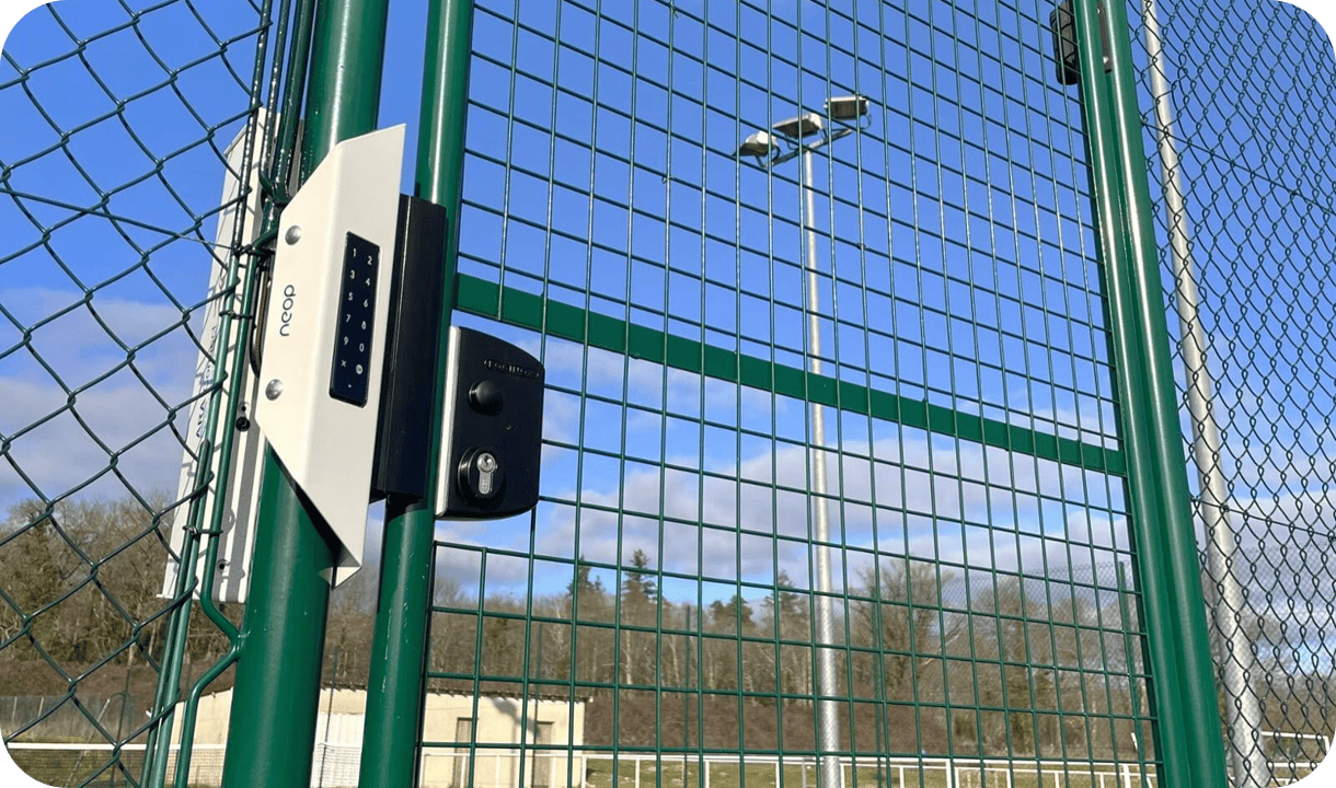 Kit serrure connectée Neop à clavier posé sur le portillon d’un court de tennis